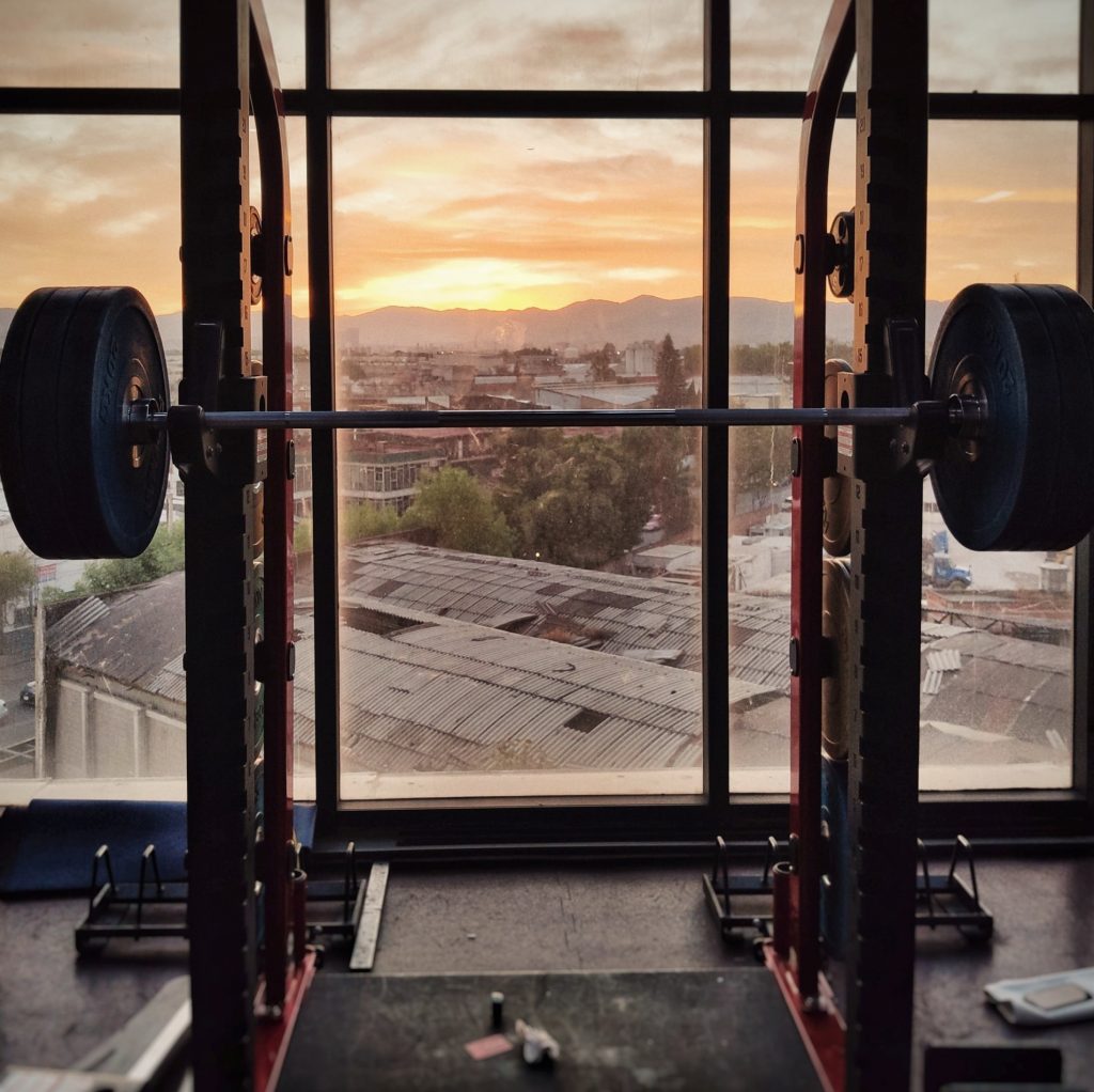 A squatting rack in a gym, relevant to the discussion of habit stacking and exercise. Read below.